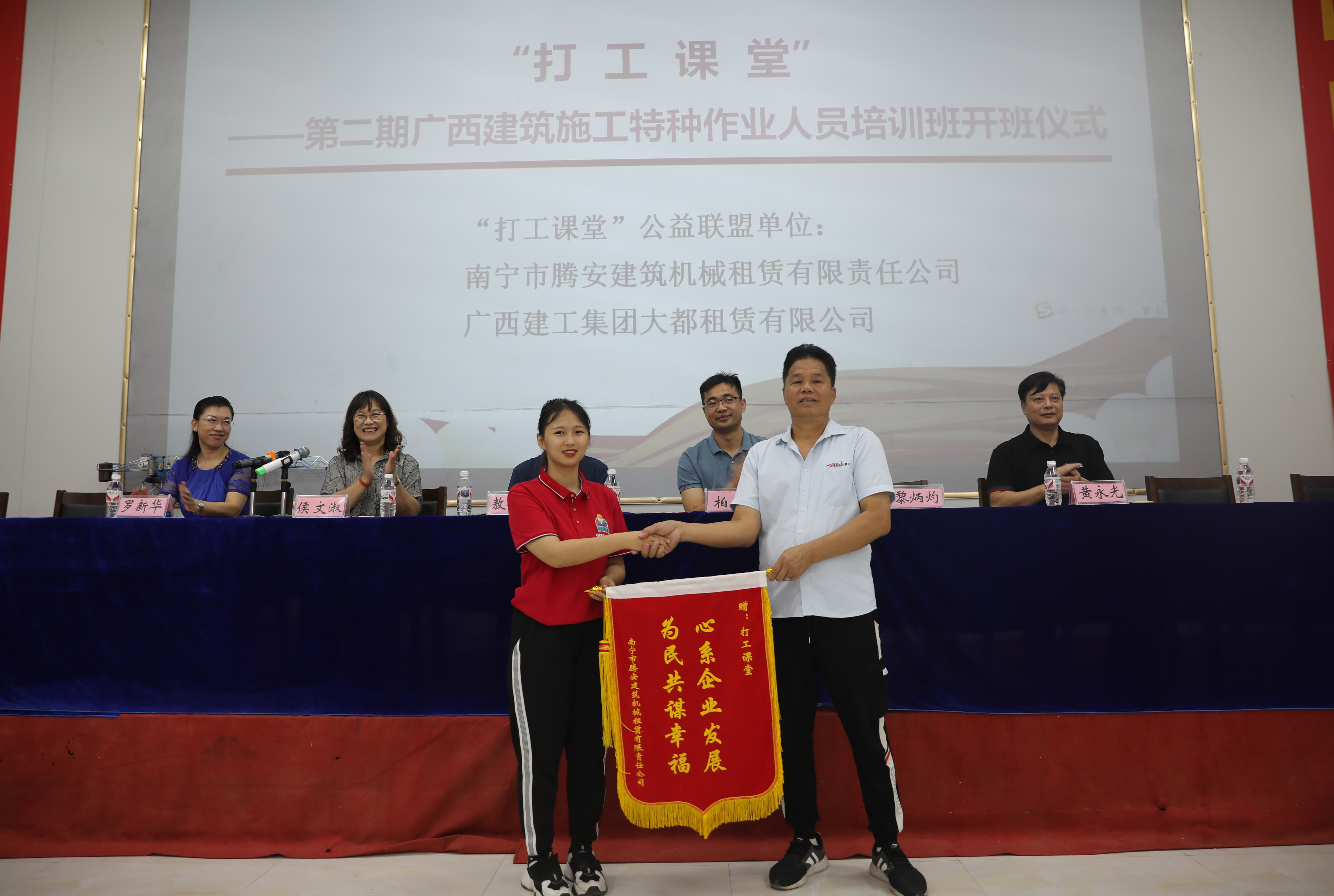 南宁市腾安公司董事长黎炳灼向“打工课堂”授予锦旗